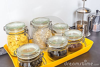 Glass stylish vintage jars with different food in the kitchen. Oatmeal, cornflakes, coffee tea Stock Photo