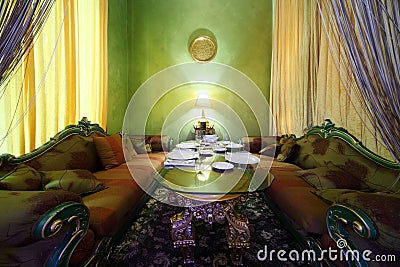 Glass table with serving and carved sofas Stock Photo