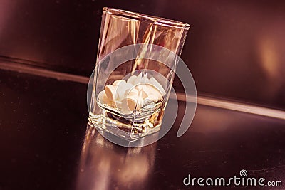 Tablets in a vodka glass. Stock Photo