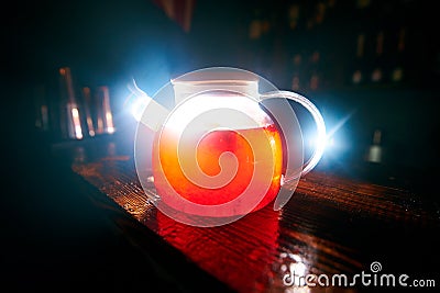 glass teapot with black tea with flash at the back Stock Photo