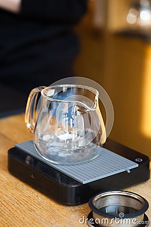 Glass teapot server on digital scales closeup on table Stock Photo