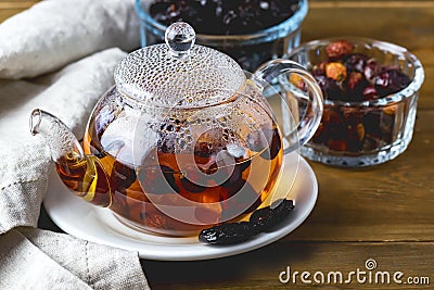 Glass Teapot of Warm Berries Tea Dried Berries and Plum Linen Napkin and Wooden Background Horizontal Rose Heap Tea Stock Photo