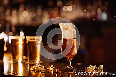 glass of unfiltered draft golden foam beer with on the bar counter Stock Photo