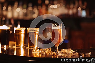 glass of unfiltered draft golden foam beer with on the bar counter Stock Photo