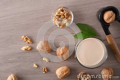 Glass of vegetable milk and walnuts on table top Stock Photo