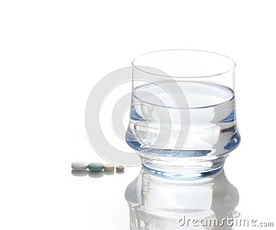 Glass of Water and Four Pills Stock Photo