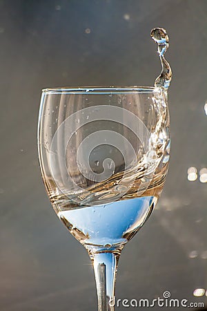 A glass of water. Frozen liquid flow above the edges of the glass Stock Photo