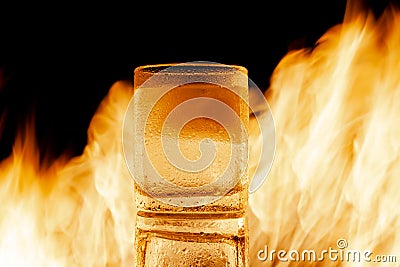 glass of water with ice against the background of fire Stock Photo