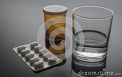 Glass of water next to blister pack of pills Stock Photo