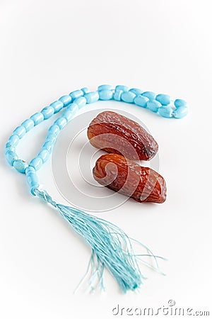 Glass of water, Organic dates Medjool and rosary. Concept breaking fast. White background. Selective focus. Copy space. Stock Photo