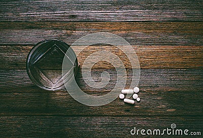 Glass of water tablets and capsules on wooden table, top view Stock Photo