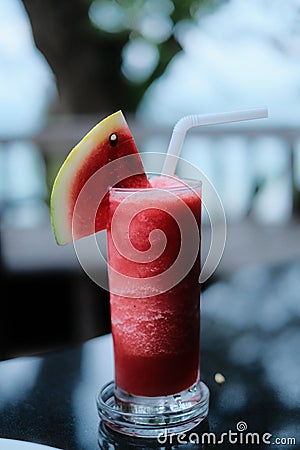 A glass of watermelon cocktail at restaurant on beach Stock Photo