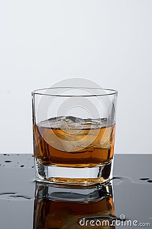 A glass of whiskey, drops, a stop time, a freeze frame with ice Stock Photo