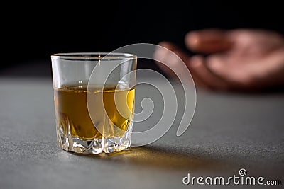 Glass of whiskey hand of a drunk man Stock Photo
