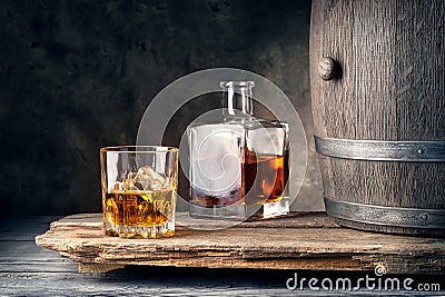 Glass of whiskey with ice decanter and barrel Stock Photo