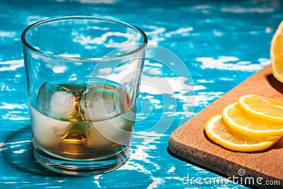 A glass of whiskey with ice and lemon on a vintage table Stock Photo