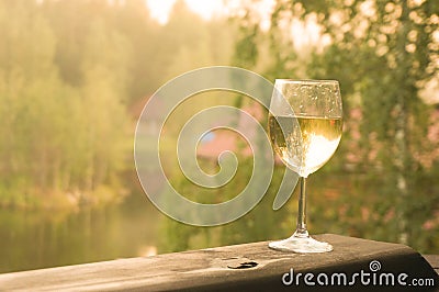 Glass of white wine on a green background of forest Stock Photo