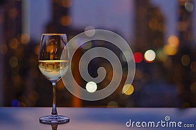 A glass of white wine on table of rooftop bar Stock Photo