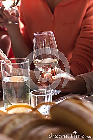 A glass of white wine in a woman's hand. Wine tasting. Stock Photo