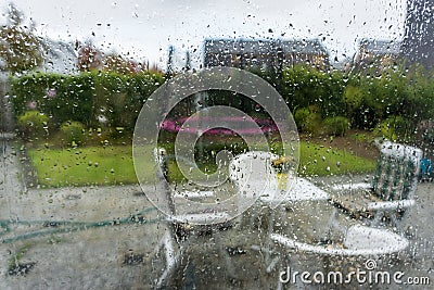 Glass window with water raindrops looking in the garden with blurry effect autumn background Stock Photo