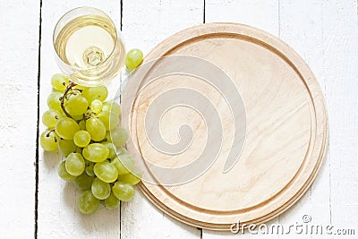 Glass of wine and grapes with empty cutting board Stock Photo