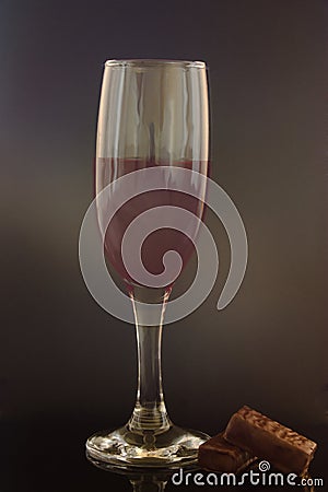 A glass of wine with two chocolates Stock Photo