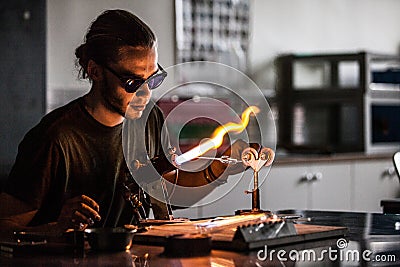 Glassblowing Young Man Working on a Torch Flame with Glass Tubes Editorial Stock Photo