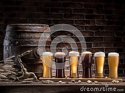 Glasses of beer and ale barrel on the wooden table. Craft brewery Stock Photo