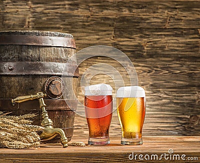 Glasses of beer and ale barrel on the wooden table. Stock Photo