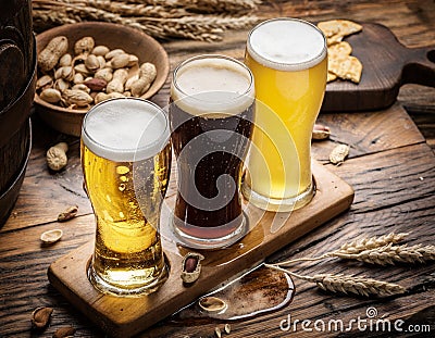 Glasses of beer and snacks on the wooden table. Stock Photo