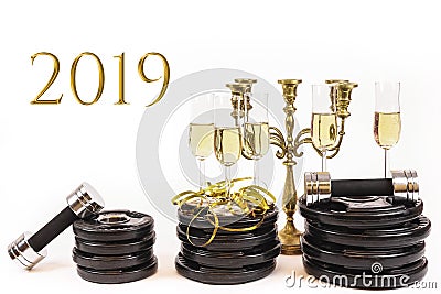 Glasses of champagne on weight plates and dumbbells. Concept for new years resolution 2019 Stock Photo