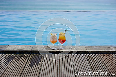 2 glasses of cocktail by the swimming pool and the sea with bokeh background Stock Photo