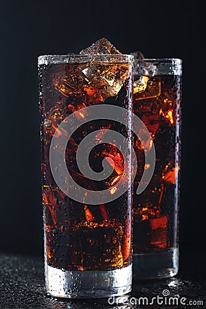 Glasses of cola with ice cubes on black stone Stock Photo