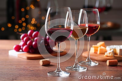 Glasses with different wines and appetizers on wooden table against blurred background Stock Photo