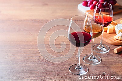 Glasses with different wines and appetizers on wooden table Stock Photo