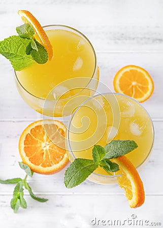 Glasses of fresh orange juice with mint and ice, orange slices on a white background, top view, cocktail Stock Photo