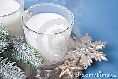 Glasses of milk, christmas tree branch, snowflake on the metal tray on the blue background Stock Photo