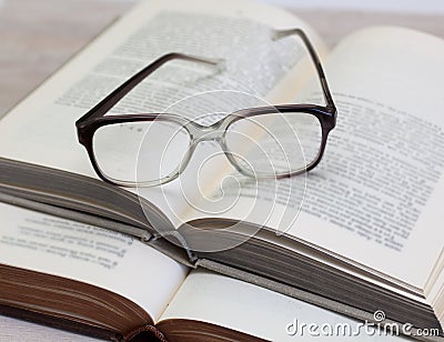 Glasses and open books on the table Stock Photo