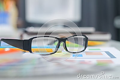 The glasses placed on the desk are pre-made glasses for working in order to increase the field of view for designers who need work Stock Photo