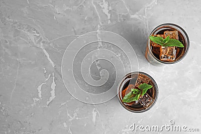 Glasses of refreshing soda drink with ice cubes and mint on grey table. Space for text Stock Photo