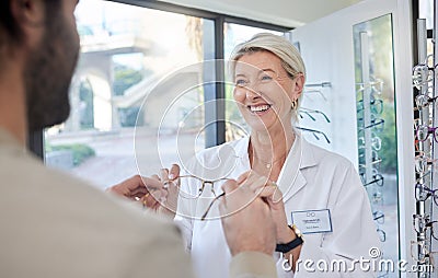 Glasses, retail shop and vision of a senior eye doctor holding a frame to help customer shopping. Happy optometrist Stock Photo