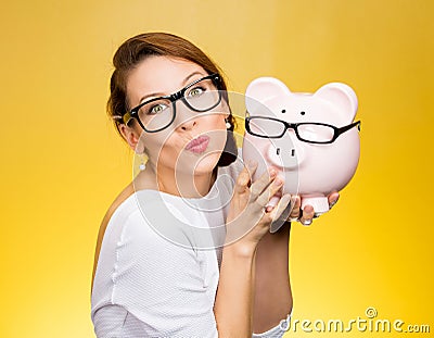 Glasses sale concept. Happy woman kissing piggy bank wearing eyewear glasses Stock Photo