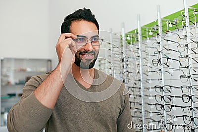 Glasses Shop. Man Trying On Eyeglasses In Optics Store Stock Photo