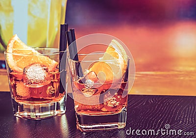 Glasses of spritz aperitif aperol cocktail with orange slices and ice cubes on bar table, vintage atmosphere background Stock Photo