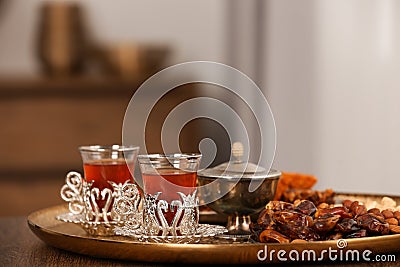 Glasses with tasty Turkish tea and oriental sweets on wooden table indoors, space for text Stock Photo