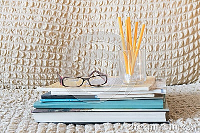 Glasses teacher books and a stand with pencils on the table. The concept of the teacher`s day. Copy space Stock Photo