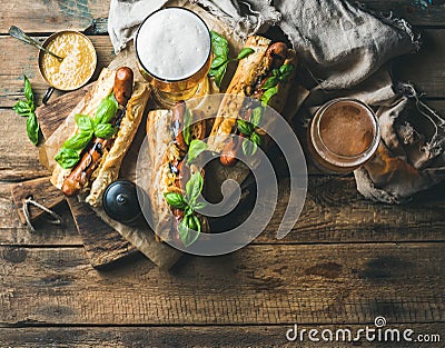 Glasses of wheat unfiltered beer and homemade grilled sausage dogs Stock Photo