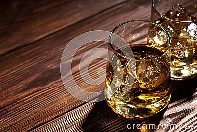 Glasses of whiskey with ice on wood Stock Photo