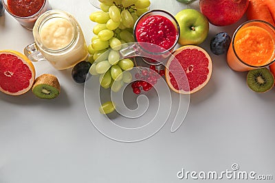 Glassware of tasty colorful smoothies with ingredients on light table Stock Photo