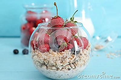 Glassware with tasty oatmeal and strawberry on color table Stock Photo